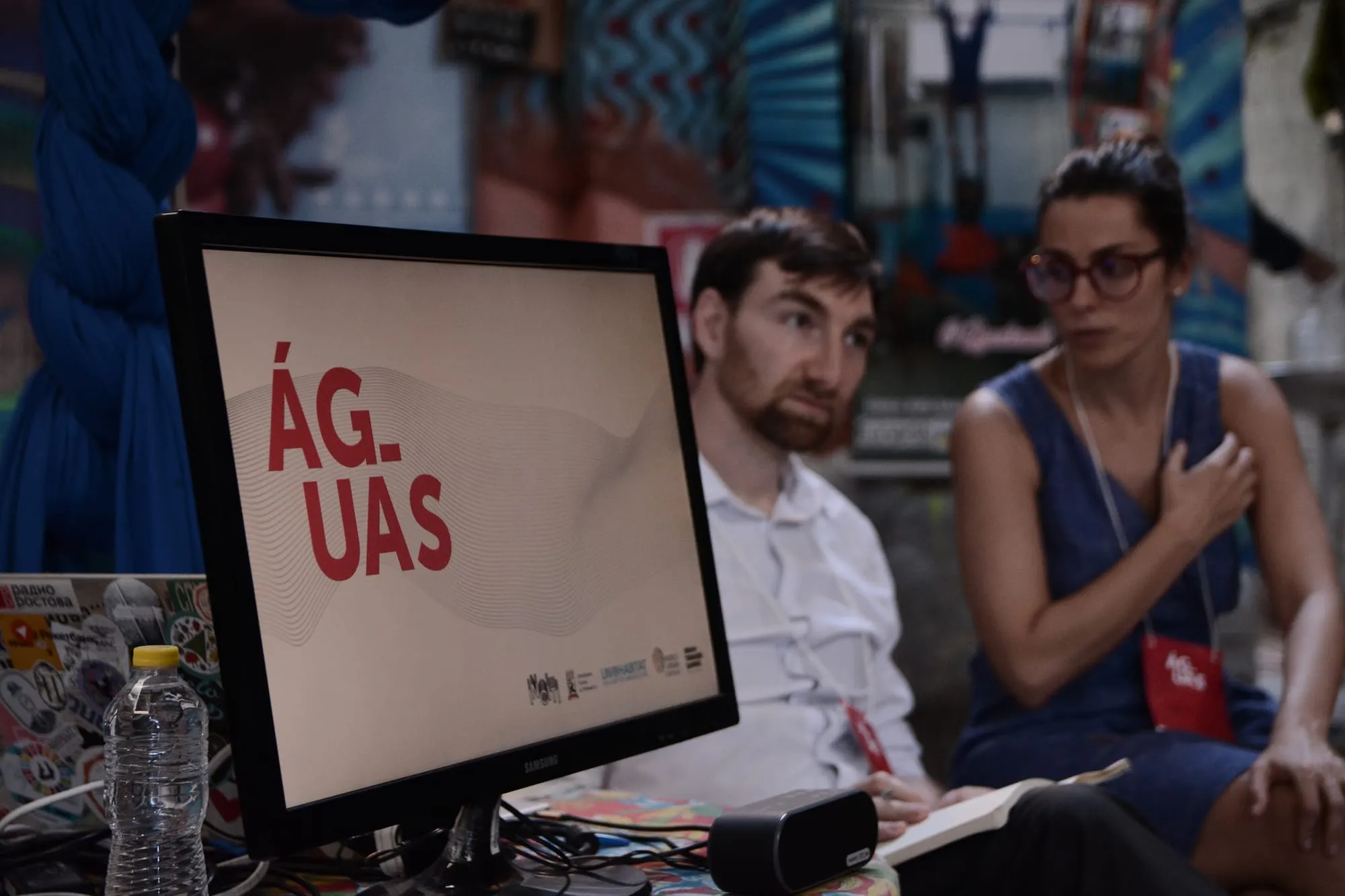 A screen reading “Águas” next to two session participants
