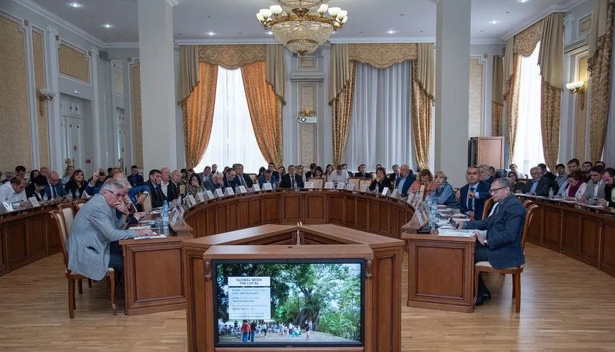A conference hall during the Small Rivers in Big Cities forum, with a slide of a riverside park on the screen
