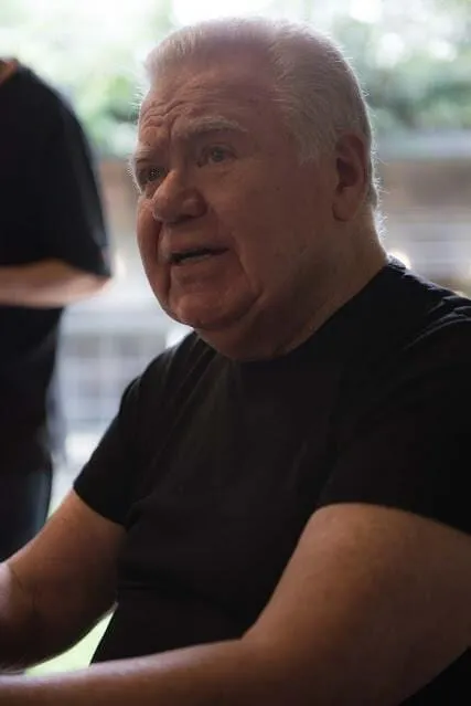 Jaime Lerner, an elderly man with white hair in a black T-shirt, speaking