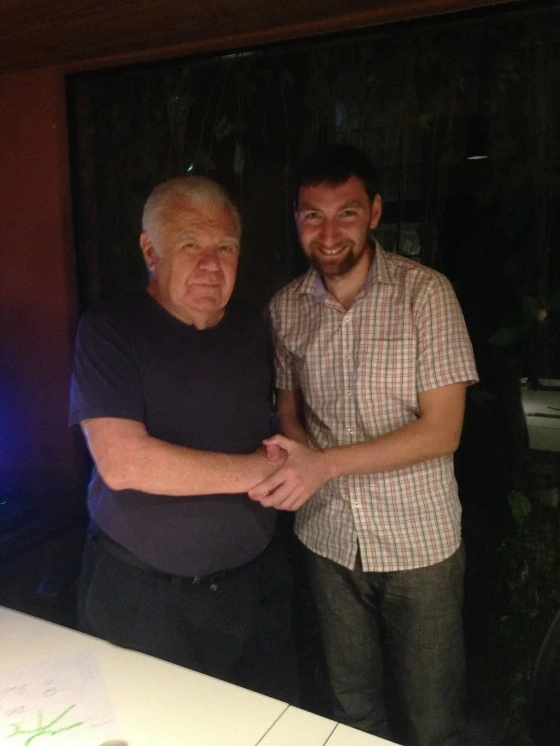 Jaime Lerner and Mihail Veklenko shaking hands in the studio in the evening