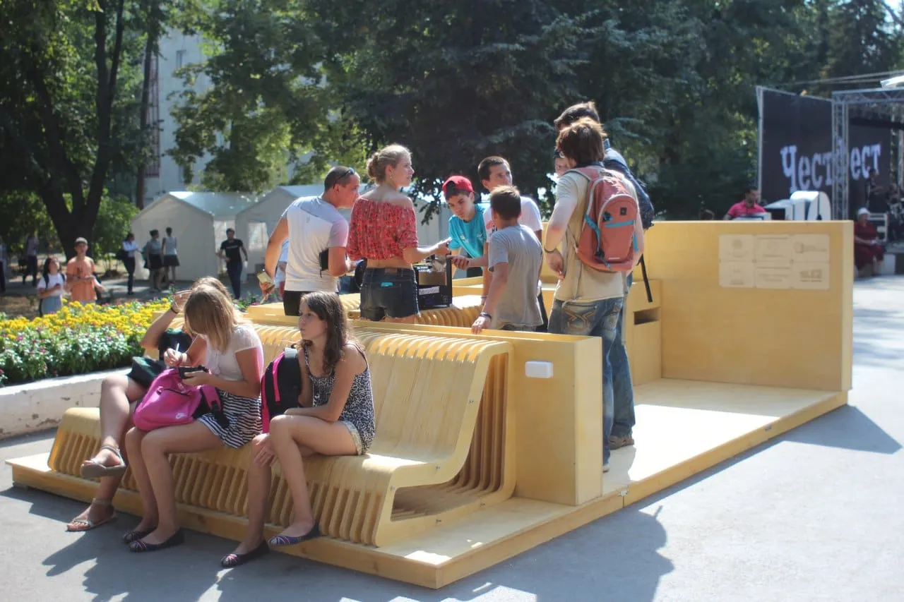 People sitting on the wooden modular micro-park in Revolution Park